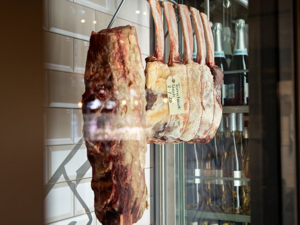 De rijpingskast achter glas met dry aged vlees