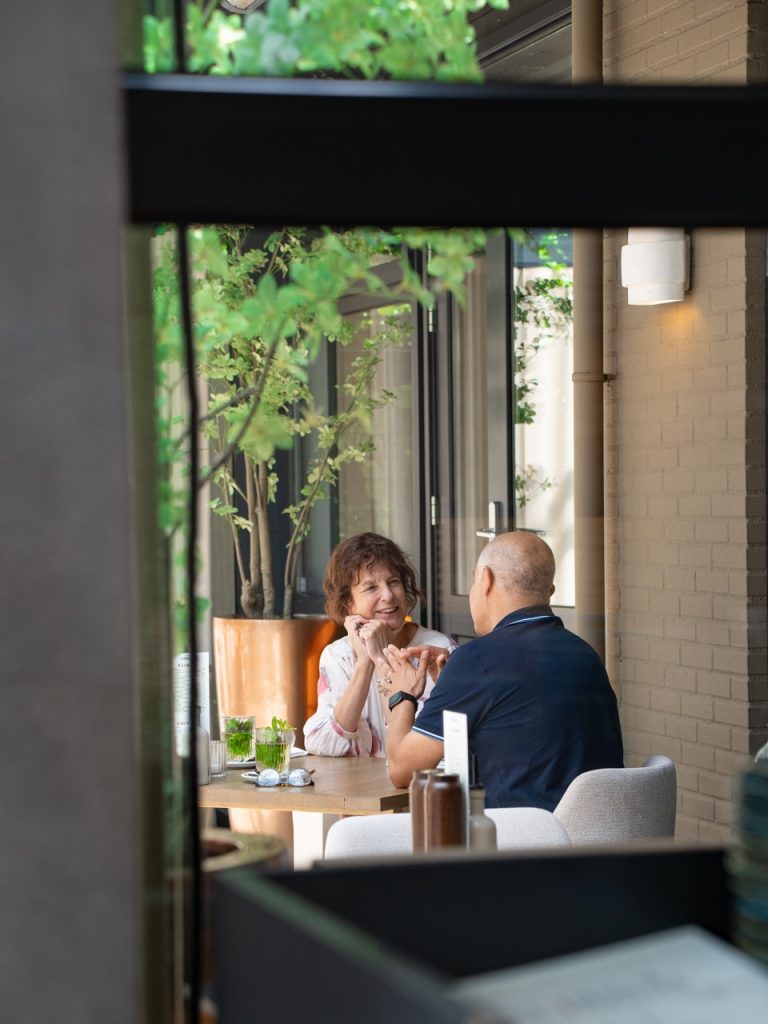 Twee gasten in gesprek aan een tafeltje op het terras van Brasserie Pastis
