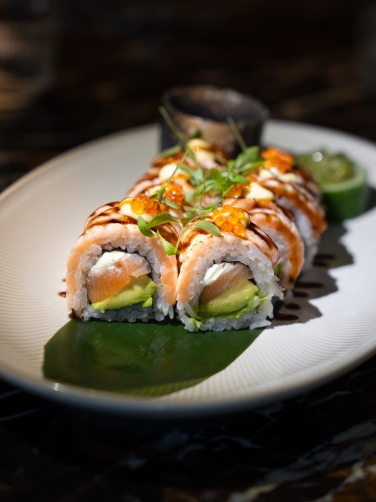Sushiroll met zalm en avocado op een groene saus bij Brasserie Pastis
