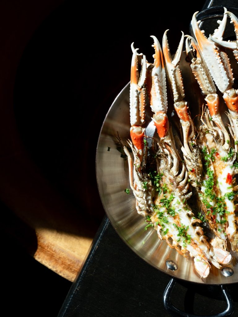 Gegrilde langoustines met kruiden in een koperen pan
